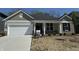 Charming single-story home showcasing a two-car garage and manicured front yard at 6474 Ambassador Dr, Plainfield, IN 46168