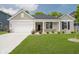 Charming single-story home featuring a manicured lawn, attached garage, and a welcoming front porch at 6474 Ambassador Dr, Plainfield, IN 46168