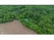 An aerial shot of the home surrounded by a dense forest, a lush field, and a winding stream at 685 N Buffalo Hill Rd, Martinsville, IN 46151