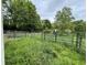 Fenced pasture with a view of the surrounding greenery and glimpses of a home in the distance at 685 N Buffalo Hill Rd, Martinsville, IN 46151