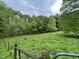 Open field with a perimeter fence surrounded by lush green trees and foliage at 685 N Buffalo Hill Rd, Martinsville, IN 46151