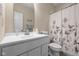 Clean white bathroom with single sink vanity and shower/tub combo at 7067 Hart St, Cumberland, IN 46229