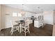 Open kitchen and dining area with white cabinets, modern appliances, and stylish dark wood flooring at 7067 Hart St, Cumberland, IN 46229