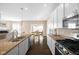 This kitchen features stainless appliances, white cabinets and flows into the dining area at 7067 Hart St, Cumberland, IN 46229