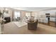 Open-concept living room with a fireplace, large windows, neutral tones, and access to the kitchen at 7067 Hart St, Cumberland, IN 46229