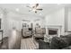 Open-concept living room featuring hardwood floors, a fireplace, and seamless flow into the kitchen at 7092 Cherry Creek Blvd, Carmel, IN 46033