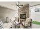 Inviting covered outdoor patio with a fireplace, ceiling fan, and comfortable seating for entertaining guests at 7092 Cherry Creek Blvd, Carmel, IN 46033