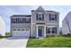 Charming two-story home featuring a blue door, attached two-car garage, and well-maintained lawn at 7195 E Rising Sun S Cir, Camby, IN 46113