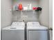Clean laundry room with a set of white GE washer and dryer, with storage shelves above at 7195 E Rising Sun S Cir, Camby, IN 46113