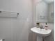 Bright powder room featuring a pedestal sink, mirrored vanity and neutral decor at 7195 E Rising Sun S Cir, Camby, IN 46113
