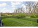 Large grassy backyard with a black fence and mature trees at 7450 Cassilly Ct, Indianapolis, IN 46278