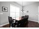 Bright dining room with dark hardwood floors, a window, and a wood table with black chairs at 7450 Cassilly Ct, Indianapolis, IN 46278