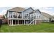 Rear exterior view of a two-story home with a deck, stairs, and a well-maintained lawn at 7450 Cassilly Ct, Indianapolis, IN 46278