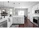 Open-concept kitchen featuring a large island, white cabinets, and stainless-steel appliances at 7450 Cassilly Ct, Indianapolis, IN 46278