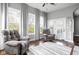 Sun-filled living room with two armchairs, hardwood floors, and large windows and door at 7450 Cassilly Ct, Indianapolis, IN 46278