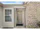 Close-up of a charming front door flanked by sidelight windows and brick detail, creating an inviting entrance at 7841 Whitaker Farms Ln, Indianapolis, IN 46237