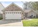 Charming brick home showcasing an attached two-car garage, a welcoming front door, and a well-maintained lawn at 7841 Whitaker Farms Ln, Indianapolis, IN 46237