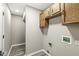 A hallway with wood flooring and overhead cabinets above the laundry hookups at 7841 Whitaker Farms Ln, Indianapolis, IN 46237