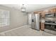 A spacious kitchen with stainless steel appliances, wood cabinets, and tile flooring under decorative pendant at 7841 Whitaker Farms Ln, Indianapolis, IN 46237
