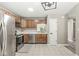 Well-lit kitchen featuring stainless steel appliances, wood cabinets, tile flooring, and a view to backyard at 7841 Whitaker Farms Ln, Indianapolis, IN 46237