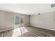 Bright living room featuring durable flooring, neutral paint, and sliding glass doors to backyard with shed at 7841 Whitaker Farms Ln, Indianapolis, IN 46237