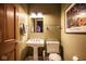 Charming powder room with pedestal sink, framed art, and towel rack at 7845 Allisonville Rd, Indianapolis, IN 46250