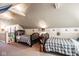 This bedroom features two twin beds with plaid covers, carpet flooring, and an attic roof at 7845 Allisonville Rd, Indianapolis, IN 46250