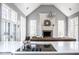 An open-concept living room featuring a fireplace, large windows, and a vaulted ceiling at 7845 Allisonville Rd, Indianapolis, IN 46250
