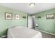 Cozy bedroom featuring refreshing green walls, natural light, and simple wall decor at 7901 Apalachee Dr, Indianapolis, IN 46217