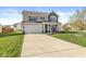Inviting two-story home with a large driveway and manicured lawn and mature trees at 7901 Apalachee Dr, Indianapolis, IN 46217