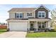 Charming two-story home with a covered front porch and an attached two-car garage at 7901 Apalachee Dr, Indianapolis, IN 46217