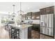 Modern kitchen with stainless steel appliances, a large center island, and dark cabinetry at 7901 Apalachee Dr, Indianapolis, IN 46217