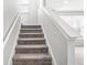 Carpeted staircase with white banister leads to a bright, inviting upper level, seamlessly connecting living spaces at 7901 Apalachee Dr, Indianapolis, IN 46217