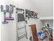 Storage area with vacuum, ladder, and tools neatly arranged against a white wall, maximizing space and organization at 7901 Apalachee Dr, Indianapolis, IN 46217