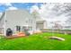 The expansive backyard features a deck, mature trees, and lush green grass, ideal for relaxation and entertainment at 853 Westpointe Dr, Shelbyville, IN 46176