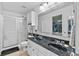 Well-lit bathroom featuring a double sink vanity with a granite countertop and a glass-enclosed shower at 853 Westpointe Dr, Shelbyville, IN 46176