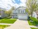 A charming two-story home boasting a well-manicured lawn, attached garage, and welcoming front porch, exuding curb appeal at 853 Westpointe Dr, Shelbyville, IN 46176