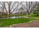 Backyard featuring a serene pond with mature trees and green grass at 8618 Turnstone Ct, Indianapolis, IN 46234