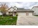 Traditional two-story home featuring a three-car garage, complemented by a lush front yard and mature trees at 8618 Turnstone Ct, Indianapolis, IN 46234