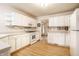 Large kitchen with white cabinetry, modern appliances, and laminate flooring, designed for both functionality and style at 8618 Turnstone Ct, Indianapolis, IN 46234