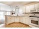 Spacious kitchen with white cabinetry, modern appliances, and hardwood floors, flowing into the adjoining living area at 8618 Turnstone Ct, Indianapolis, IN 46234