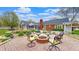 Inviting backyard patio with comfortable seating around a brick fire pit, surrounded by lush landscaping at 8842 Rocky Ridge Rd, Indianapolis, IN 46217