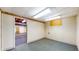 Finished basement featuring bright lighting, white walls, and door opening to another carpeted room at 8842 Rocky Ridge Rd, Indianapolis, IN 46217