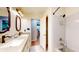 Well-lit bathroom featuring double sinks, granite countertops, and a shower-tub combo at 8842 Rocky Ridge Rd, Indianapolis, IN 46217