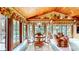 Bright dining area with wood-paneled ceiling, large windows, and a round wooden table perfect for Gathering gatherings at 8842 Rocky Ridge Rd, Indianapolis, IN 46217