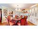 Elegant dining room with wood table, red chairs, chandelier, and built-in display cabinets at 8842 Rocky Ridge Rd, Indianapolis, IN 46217