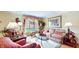 Cozy living room with hardwood floors, floral sofa, lamps, and large windows with decorative curtains at 8842 Rocky Ridge Rd, Indianapolis, IN 46217