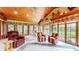 Bright sunroom boasts a wooden ceiling, large windows, and comfortable seating at 8842 Rocky Ridge Rd, Indianapolis, IN 46217