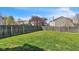 Lush backyard with a wooden fence, mature trees, and a green lawn at 8888 N White Tail N Trl, McCordsville, IN 46055