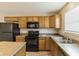 Kitchen featuring oak cabinets, black appliances, a double sink, a window, and neutral paint at 8888 N White Tail N Trl, McCordsville, IN 46055